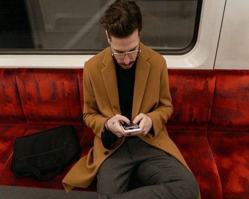 Urban transportation setting in Chile, depicting a person using a smartphone comfortably during a commute